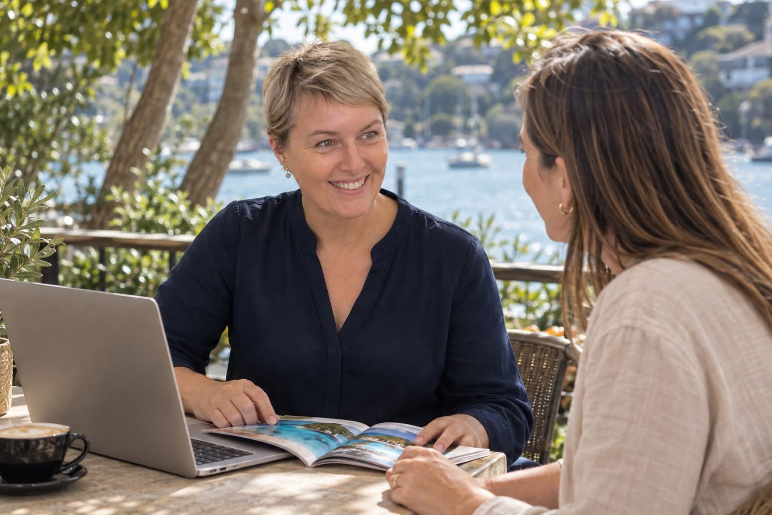 Tanya discussing travel plans with a client by the water